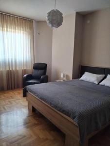 a bedroom with a bed and a chair at Tea in Niš