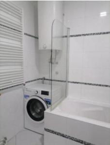 a washing machine in a white room with a window at Tea in Niš