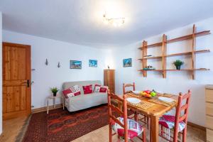a dining room with a table and a couch at Montagne E Coccole - Happy Rentals in Pré-Saint-Didier