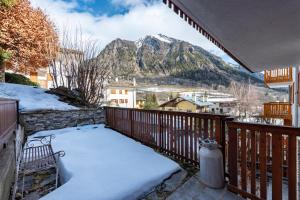 a balcony with a snow covered bench and a mountain at Montagne E Coccole - Happy Rentals in Pré-Saint-Didier +21 photos