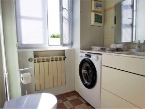 a bathroom with a washing machine and a sink at Le Mistral Saint Gilles Croix de Vie in Les Bussolleries