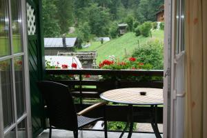 a table and chairs on a balcony with a view at Ferienwohnungen Martinsklause in Ramsau