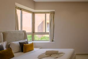 ein Schlafzimmer mit einem Bett und einem großen Fenster in der Unterkunft Luxury 2BD in Prestigia Jade with Pool and Golf View in Marrakesch + 34 Fotos