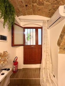 una camera con porta in legno e finestra di L'Antica Dimora Deluxe a Bari
