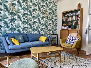 a living room with a blue couch and a table at Youyou Saint Gilles Croix de Vie in Les Bussolleries
