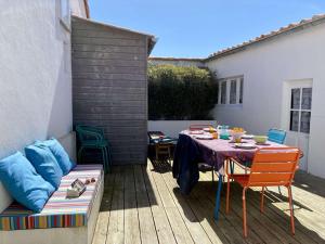 a patio with a table and chairs and a couch at Youyou Saint Gilles Croix de Vie in Les Bussolleries +10 photos