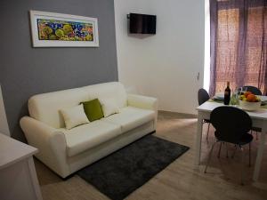a living room with a white couch and a table at Donsanto Casa Vacanze in Taormina