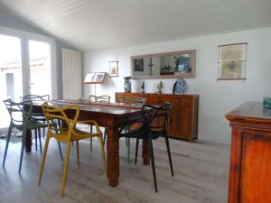 una sala da pranzo con tavolo e sedie in legno di Les Treilles Saint Hilaire de Riez a Notre-Dame-de-Riez