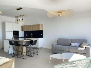 un salon avec un canapé et une cuisine dans l'établissement Evasion Saint Hilaire de Riez, à Sion-sur-lʼOcéan