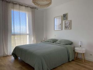 une chambre avec un lit et une grande fenêtre dans l'établissement Evasion Saint Hilaire de Riez, à Sion-sur-lʼOcéan