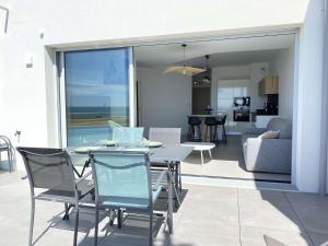 un patio avec une table et des chaises et un salon dans l'établissement Evasion Saint Hilaire de Riez, à Sion-sur-lʼOcéan