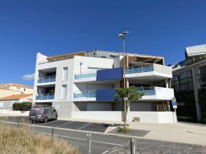 un bâtiment blanc avec une camionnette garée devant. dans l'établissement Evasion Saint Hilaire de Riez, à Sion-sur-lʼOcéan 4 autres photos