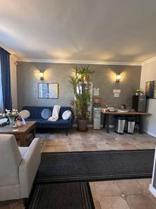 salon z niebieską kanapą i stołem w obiekcie Jager Guesthouse w mieście Sopron
