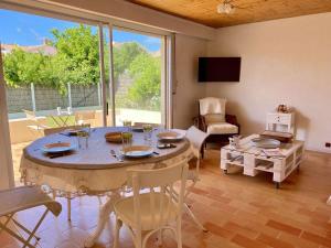un comedor con mesa y sillas y una habitación con ventana en Rivage - Saint Hilaire de Riez, en Les Bussolleries 6 fotos más