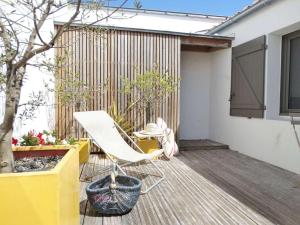 a white chair sitting on a wooden deck at Tulipe Saint Gilles Croix de Vie in Saint-Gilles-Croix-de-Vie
