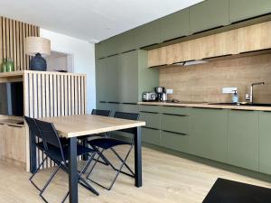 une cuisine avec une table et des chaises en bois dans l'établissement Corsaire Saint Gilles Croix de Vie, à Saint-Gilles-Croix-de-Vie