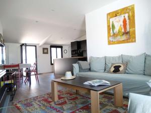 Transat Saint Gilles Croix de Vie في سانت جيل كروا دي فيي: غرفة معيشة مع أريكة زرقاء وطاولة