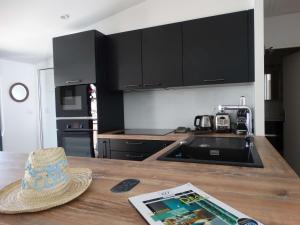 Transat Saint Gilles Croix de Vie في سانت جيل كروا دي فيي: مطبخ مع طاولة عليها قبعة