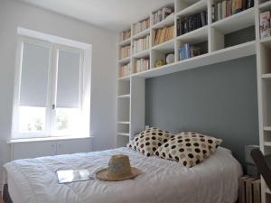 Transat Saint Gilles Croix de Vie في سانت جيل كروا دي فيي: غرفة نوم مع سرير مع قبعة عليه +صورتان