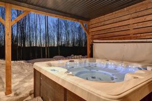 a jacuzzi tub in a cabin with a window at Havre de Paix in Saint-Rémi-dʼAmherst