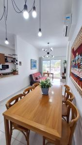 a dining room with a wooden table and chairs at Apartamento em Ubatuba in Ubatuba