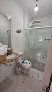 a bathroom with a shower and a toilet and a sink at Apartamento em Ubatuba in Ubatuba