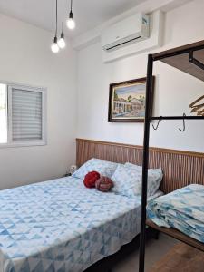 a bedroom with a bed with a blue comforter at Apartamento em Ubatuba in Ubatuba