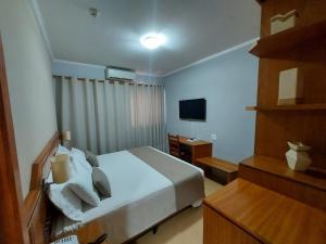 a hotel room with a bed and a television at Hotel Tenda in Marília +100 photos