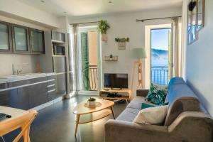 a living room with a couch and a table at Les Sablettes in Menton