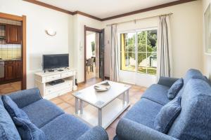 un soggiorno con un divano blu e un tavolo di 27 Terracos de Benagil - Casa Oceane a Benagil