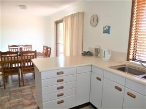 a kitchen with white cabinets and a sink and a table at Bear's Hideaway in Harrington