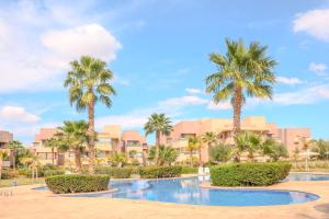 ein Resort mit Palmen und einem Swimmingpool in der Unterkunft Luxury 2BD in Prestigia Jade with Pool and Golf View in Marrakesch