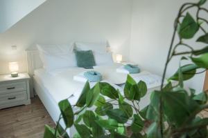 a bedroom with a white bed with two pillows at DANESSI-25Min bis Koblenz,Familie,Balkon,Parkplatz,Top Ausstattung,2 Bäder,Waschmaschine,Spülmaschine,Arbeitsplatz-Perfekt für Urlaub und Business mit der Familie in Straßenhaus