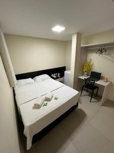 a bedroom with a bed and a desk with a chair at Grace Palace Hotel in Sobral