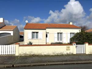 a white house with a fence in front of it at La Bussolerie de la mer - Saint Hilaire de Riez in Saint-Hilaire-de-Riez