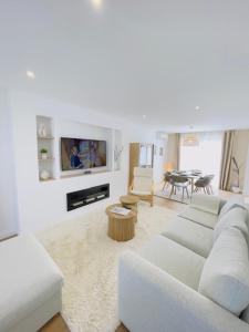 a white living room with a couch and a table at Le Luxury Lodge - 8 Voyageurs - Parking et Wifi in Mulsanne