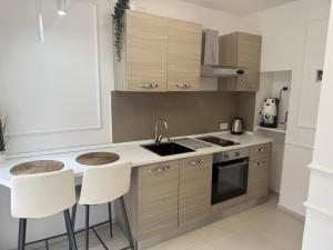 a kitchen with a sink and a counter with stools at casa effe 2 in Naples