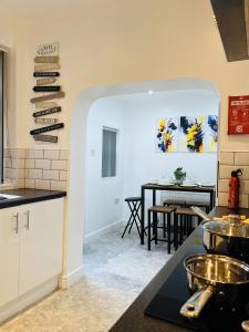 a kitchen and dining room with a table in the background at Ideal 3 bed pay-as-you-stay home in Wigan sleeps 6 in Wigan +36 photos