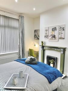 a bedroom with a bed with a blue blanket and a fireplace at Ideal 3 bed pay-as-you-stay home in Wigan sleeps 6 in Wigan