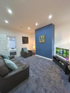 a living room with a couch and a flat screen tv at Ideal 3 bed pay-as-you-stay home in Wigan sleeps 6 in Wigan