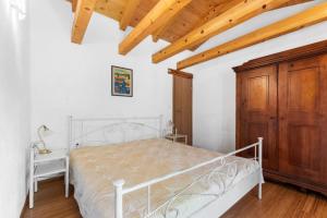 a bedroom with a white bed and a wooden cabinet at Holiday House with Private Pool Villa Ladybug in Milotski Breg
