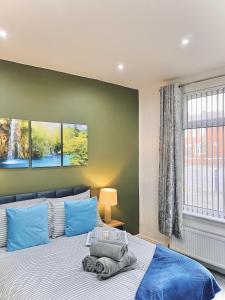 a bedroom with a large bed with blue pillows at Ideal 3 bed pay-as-you-stay home in Wigan sleeps 6 in Wigan