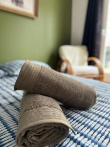 toalla enrollada encima de la cama en Chez Sonia, en Granville