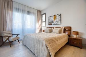 a bedroom with a bed and a chair and a window at DownTown Villa 2 in Paphos +14 photos