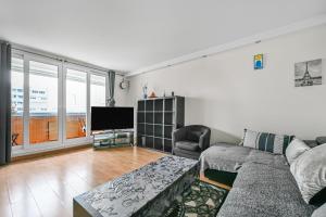 a living room with a couch and a tv at Le Spot - La Défense - Paris - Wifi in Puteaux +2 photos