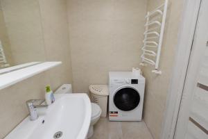 a bathroom with a washing machine next to a toilet at Apartament Centru in Chişinău