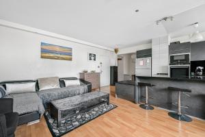 a living room with a couch and a kitchen at Le Spot - La Défense - Paris - Wifi in Puteaux