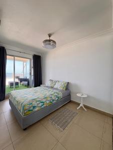 a bedroom with a bed and a table and a window at 101 Camarque - 3 Bedroom Apartment With Amazing Sea Views In Umdloti in Umdloti