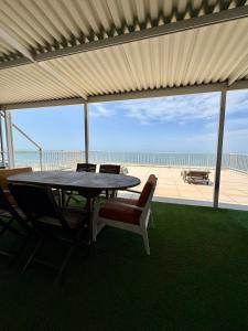 a table and chairs with a view of the beach at 101 Camarque - 3 Bedroom Apartment With Amazing Sea Views In Umdloti in Umdloti +51 photos
