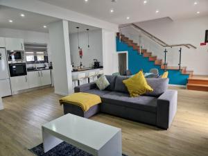 a living room with a grey couch and a kitchen at Beautiful Modern Townhouse with Parking Included in Machico